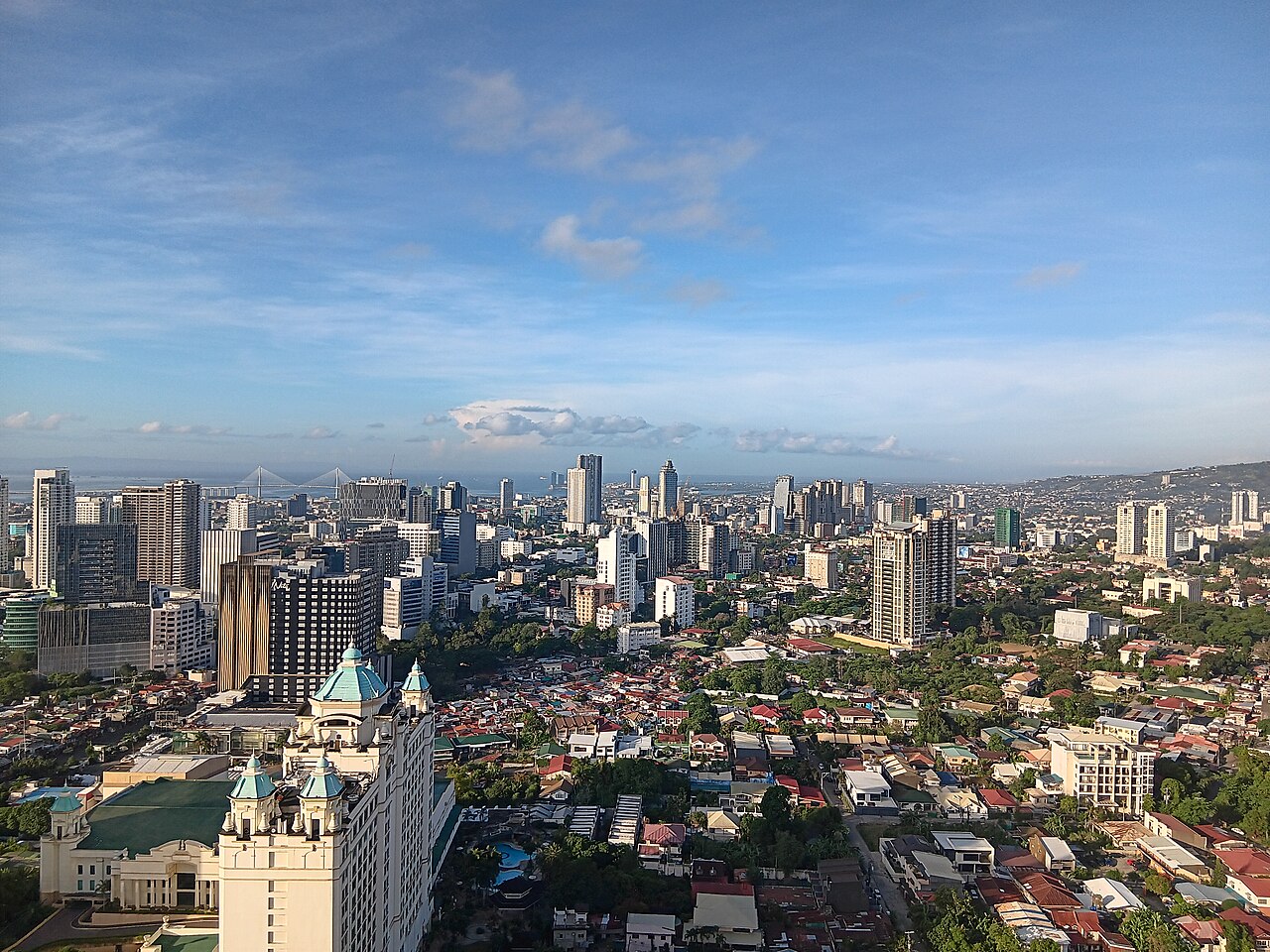 The Cebu skyline across the water, with the Cebu–Cordova Link Expressway in the foreground