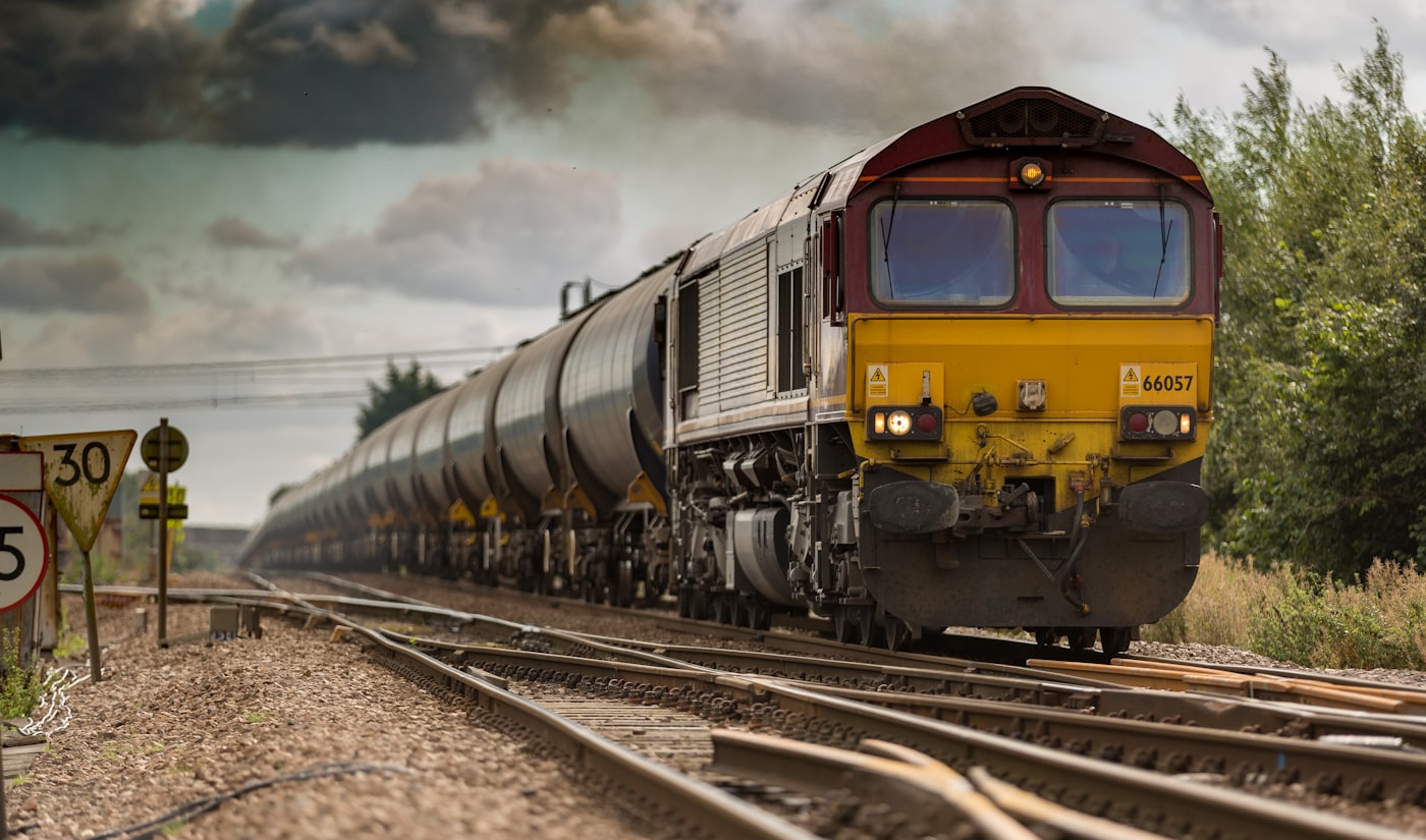 Passenger train moving through a city at dusk