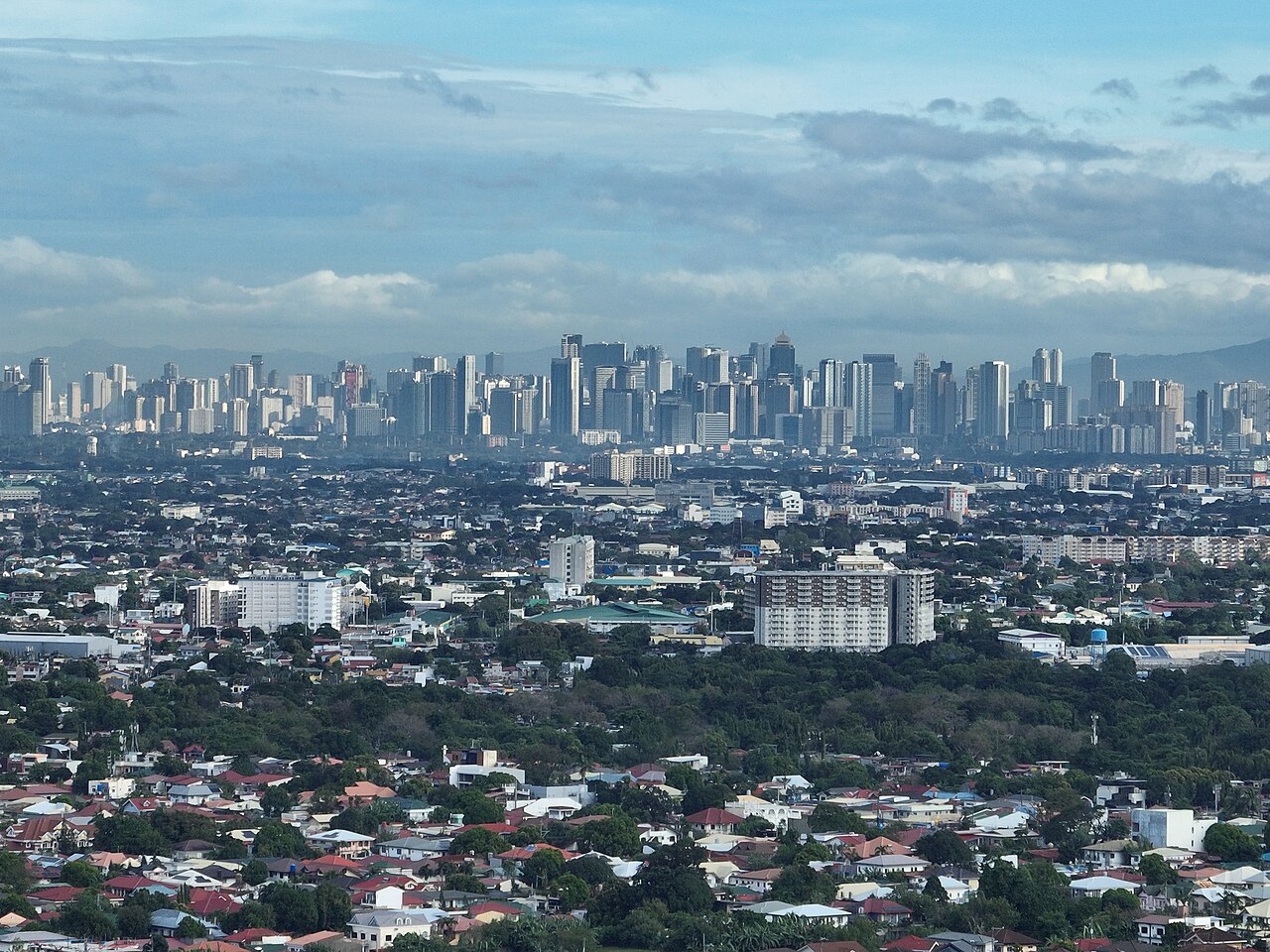 Bonifacio Global City towers seen across lower-rise neighbourhoods in Metro Manila