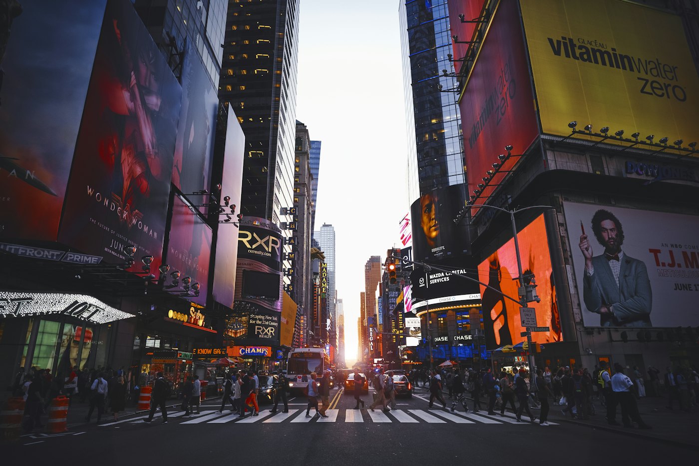 Times Square at dusk, with billboards above a crowded crossing