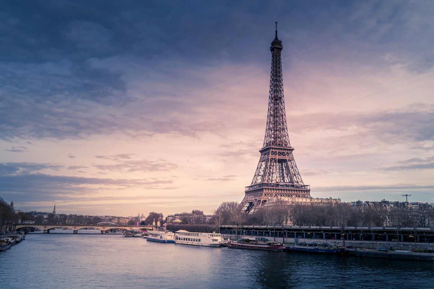 The Eiffel Tower and river boats on the Seine at dusk